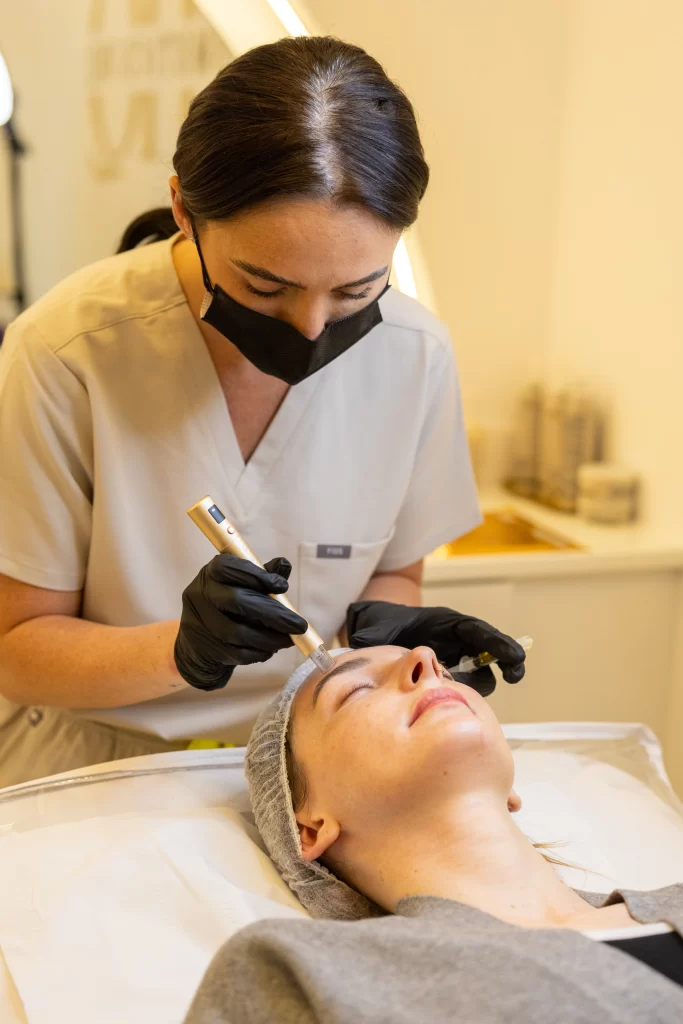 A beauty technician applying a treatment to a clients face