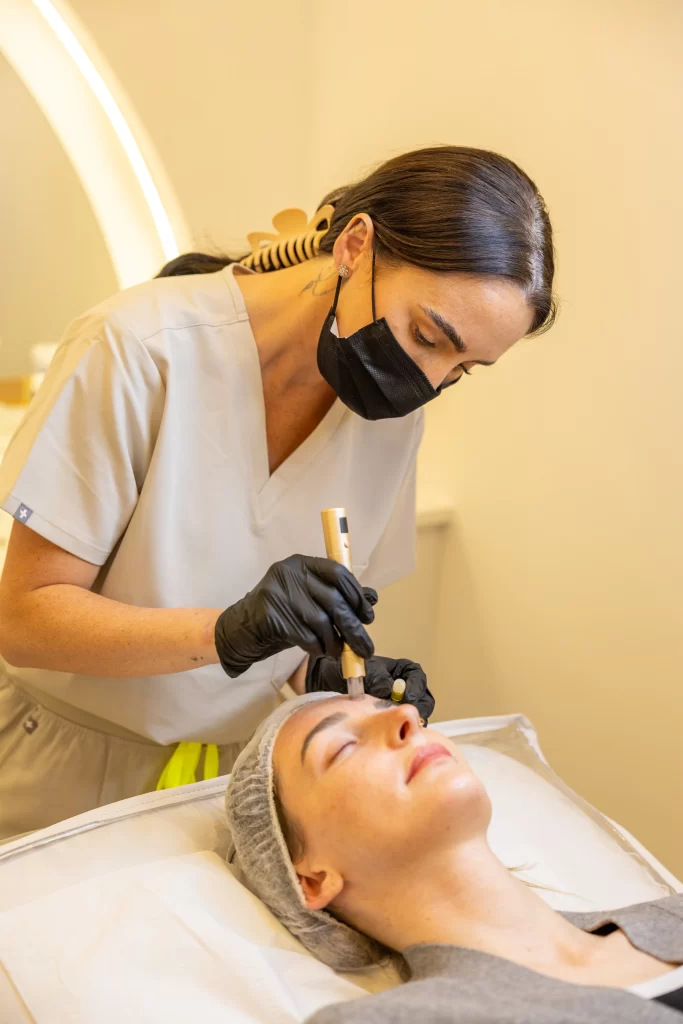 A beauty technician applying a treatment to a clients face