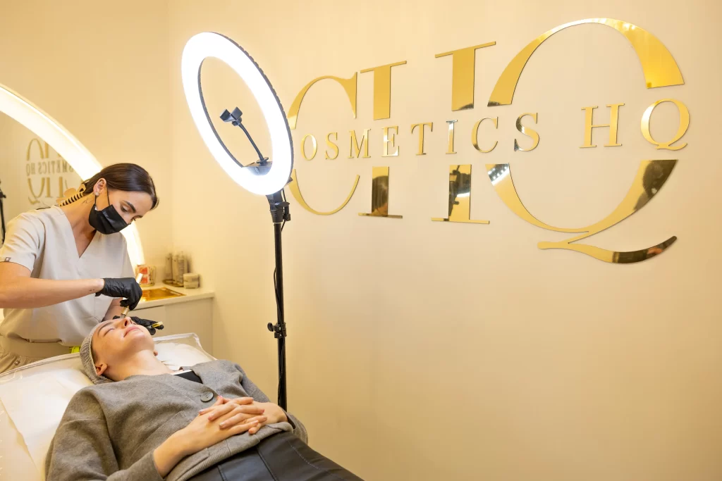 A beauty technician applying a treatment to a clients face