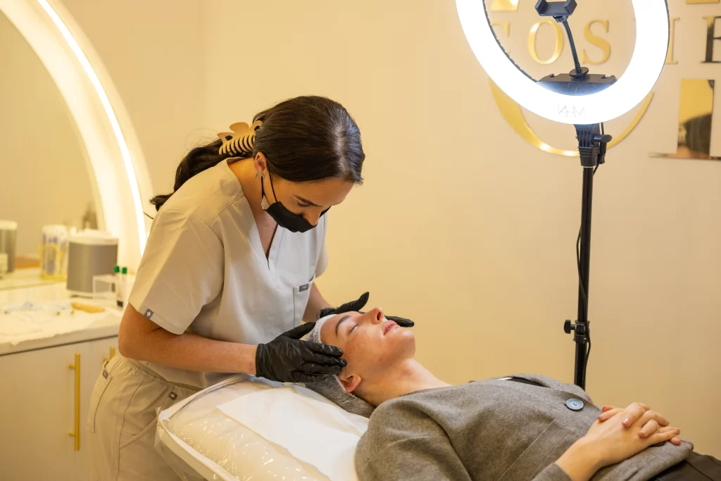 A beauty technician with a client