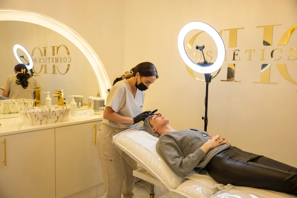 A beauty technician with a client