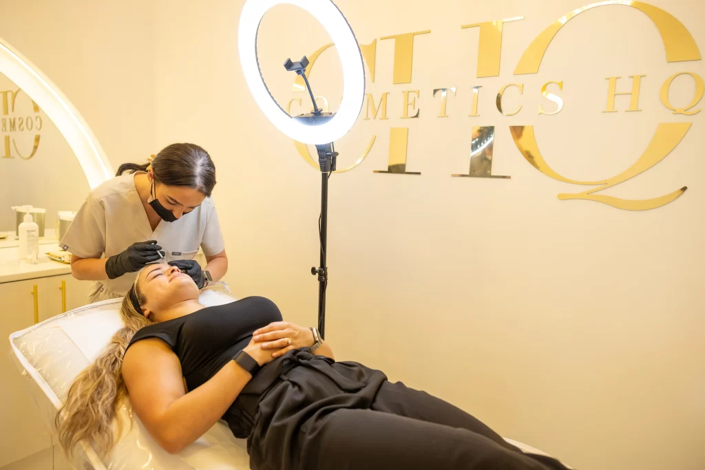 A beauty technician injecting an anti wrinkle treatment to a clients forehead