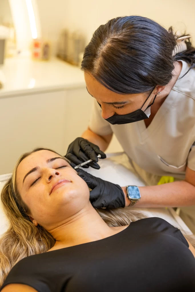 A beauty technician injecting a anti wrinkly treatment to a clients face