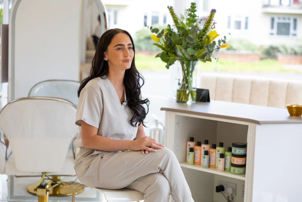 A Cosmetics HQ team member sat at the salon reception desk